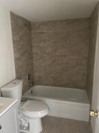 105 Mansfield F, Unit C Boca Raton, FL 33434 - Photo 13 of 14 a bathroom with a sink a toilet and bathtub