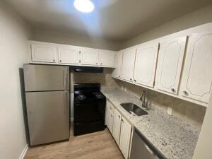 105 Mansfield F, Unit C Boca Raton, FL 33434 - Photo 4 of 14 a kitchen with a sink a refrigerator and cabinets