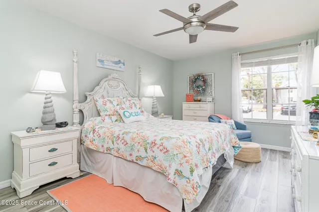 a bedroom with a bed chandelier and a window