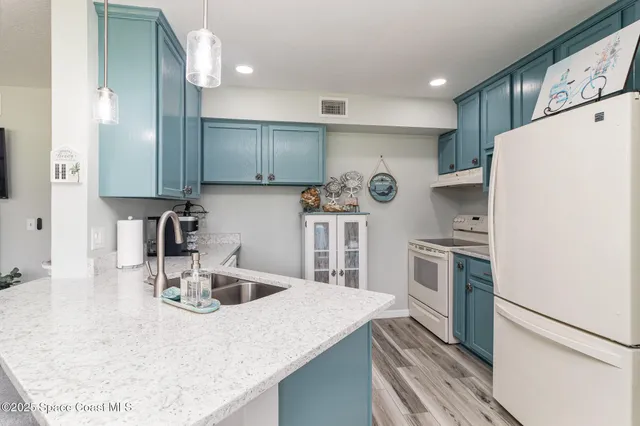 a kitchen with kitchen island a sink stove and refrigerator