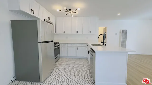 a kitchen with a sink a refrigerator and cabinets