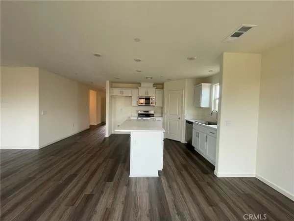a kitchen with granite countertop white cabinets and white appliances