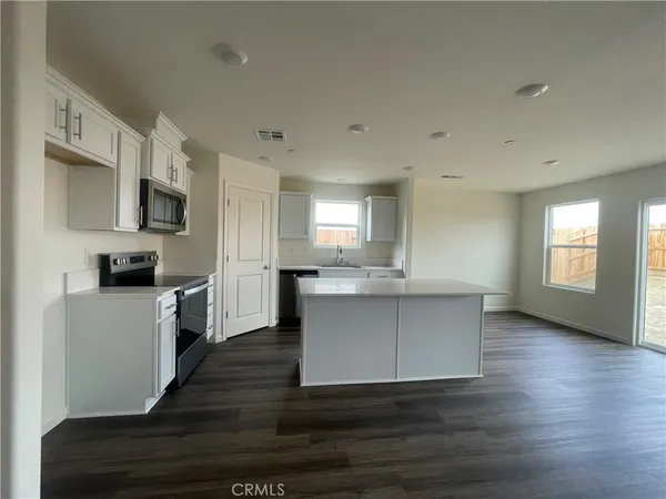 a large kitchen with cabinets wooden floor and stainless steel appliances
