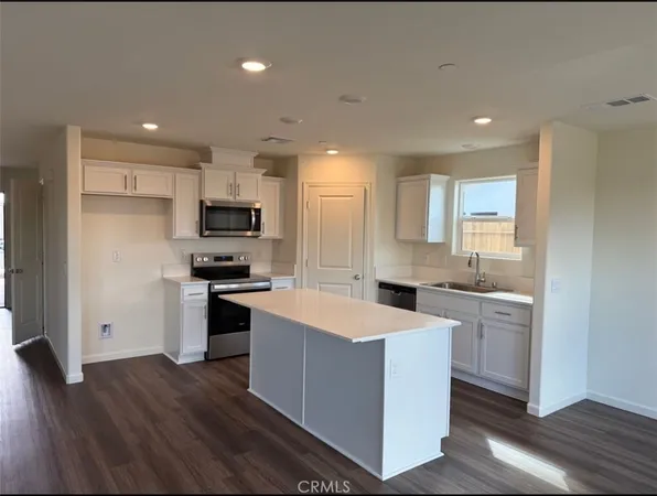 a kitchen with a sink a stove a refrigerator and a microwave