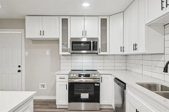 a kitchen with stainless steel appliances a sink stove and cabinets