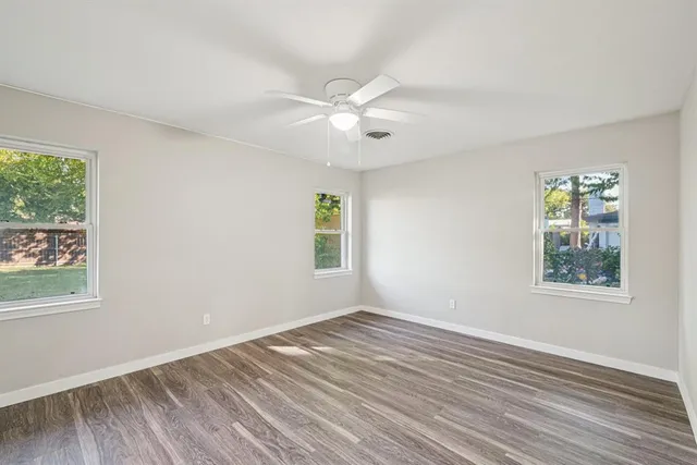 a view of an empty room with wooden floor