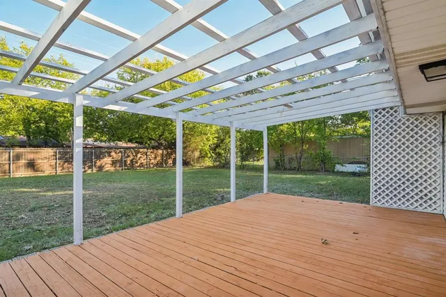 a view of an empty room with wooden floor and windows