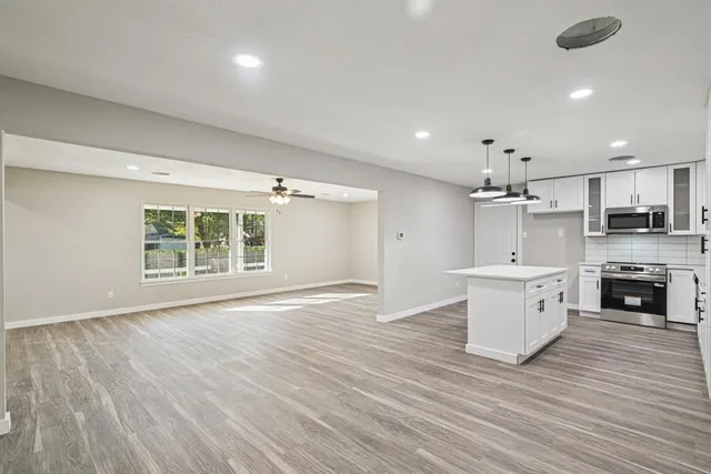 a kitchen with stainless steel appliances a stove a sink and white cabinets