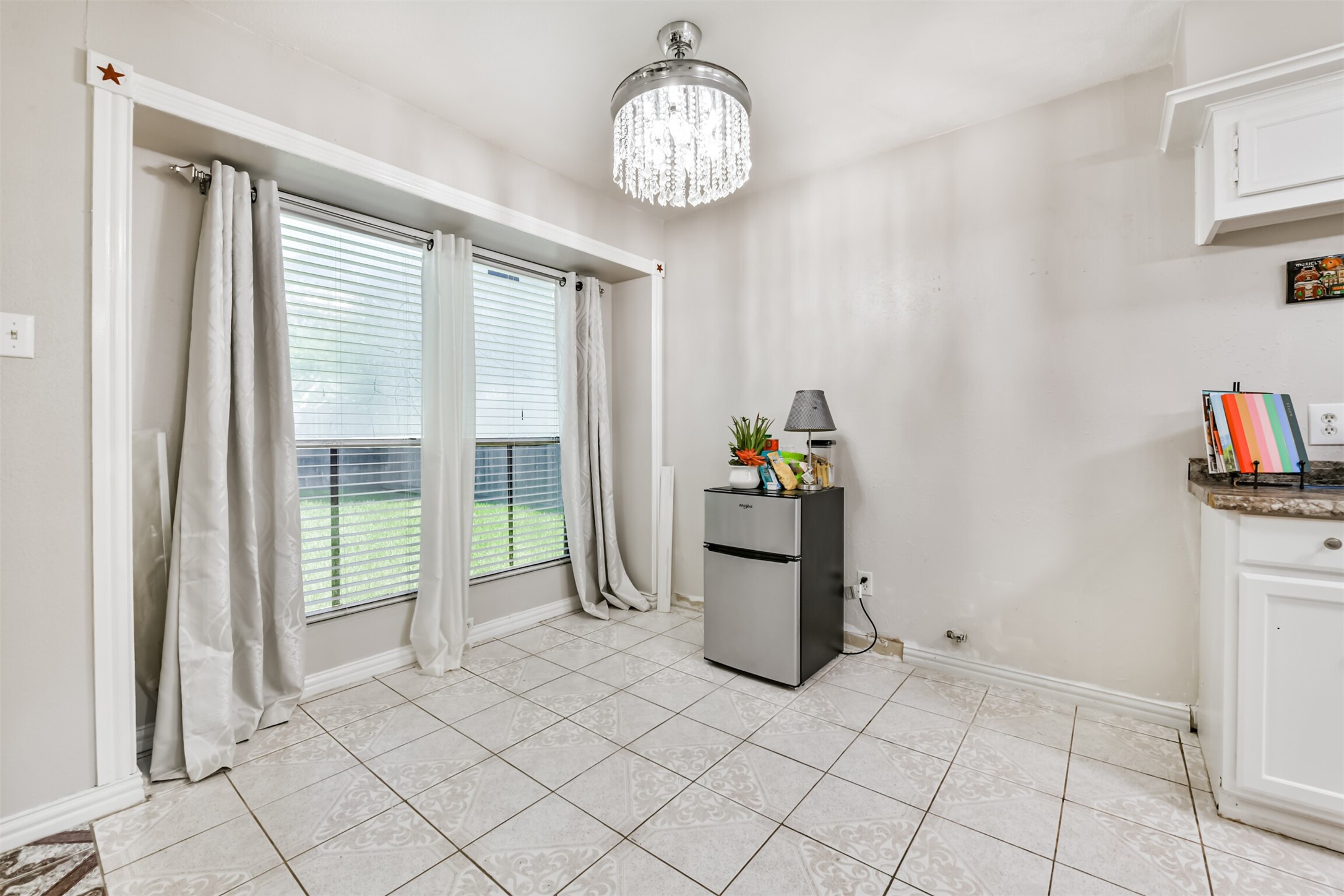 15105 Silverman Street Houston, TX 77598 - Photo 13 of 26 The dining room features curtains and two-inch blinds, offering a pleasant view of the backyard.