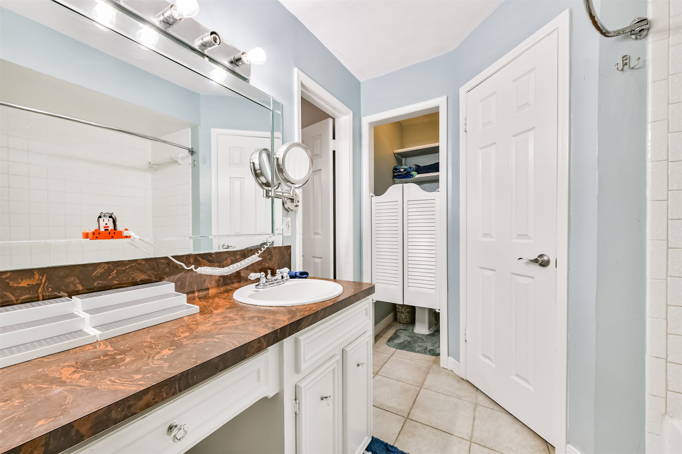 15105 Silverman Street Houston, TX 77598 - Photo 17 of 26 A sophisticated vanity with dual sinks, a walk-in closet, and a private enclosed commode.