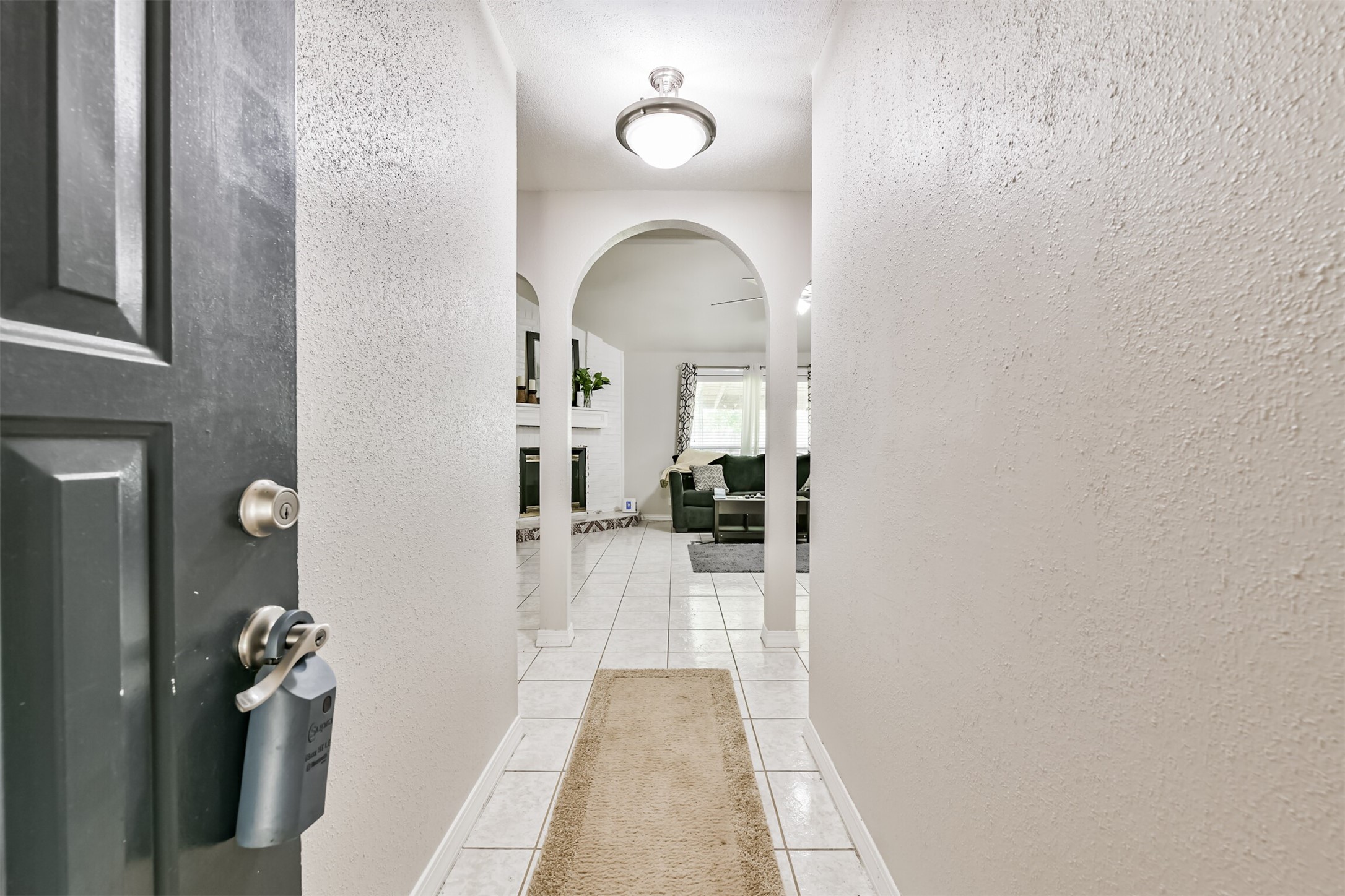15105 Silverman Street Houston, TX 77598 - Photo 4 of 26 A welcoming foyer features elegant arches and expansive tiling, seamlessly guiding you into the heart of the home—the family room.