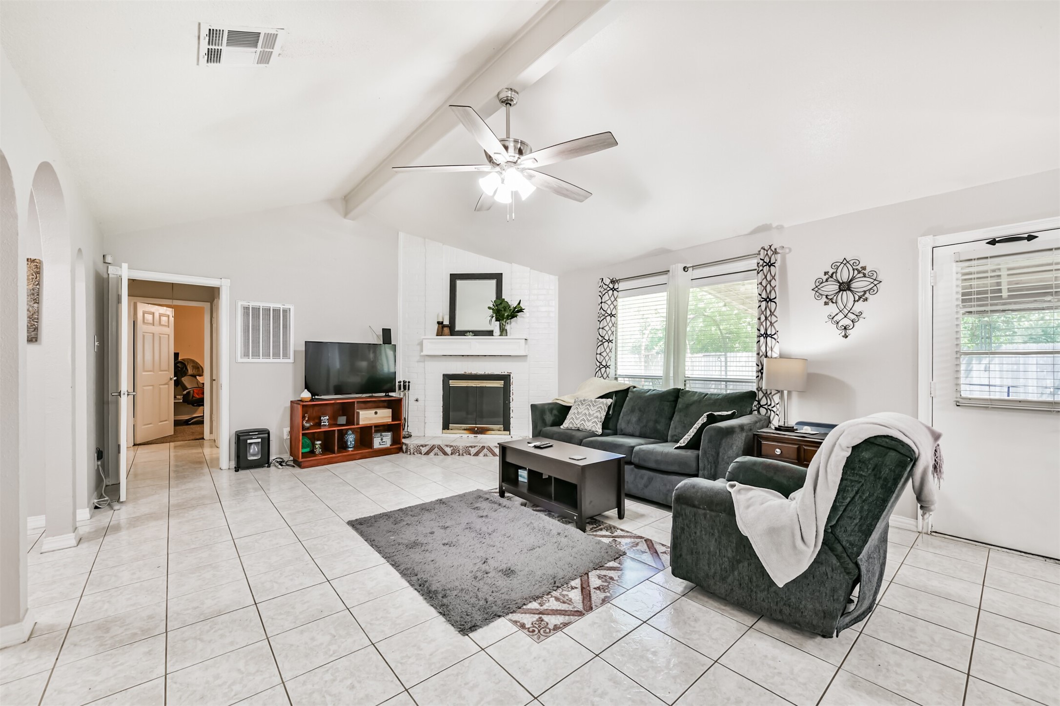 15105 Silverman Street Houston, TX 77598 - Photo 7 of 26 Elegant ceramic tile flooring, complemented by large windows adorned with curtains and 2-inch blinds.