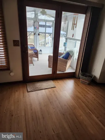a view of a living room with wooden floor and a window