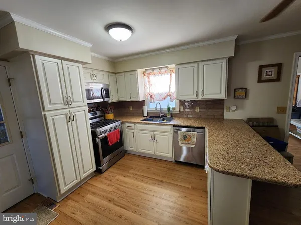 a kitchen with a refrigerator a sink a stove a microwave and island