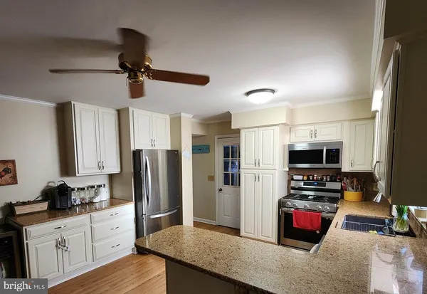 a kitchen with stainless steel appliances a refrigerator and a stove top oven