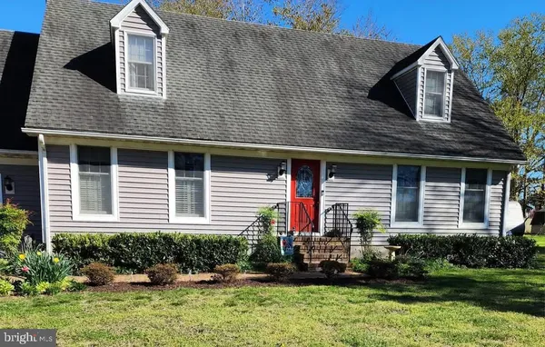 a front view of a house with a yard and potted plants