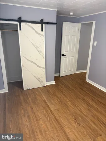 an empty room with wooden floor and closet