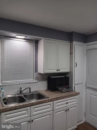 a kitchen with stainless steel appliances granite countertop white cabinets and a sink