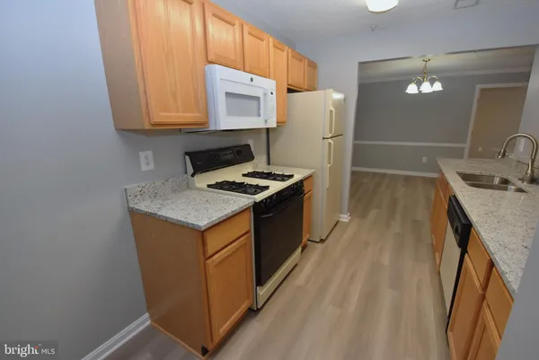a kitchen that has a sink a stove and a refrigerator