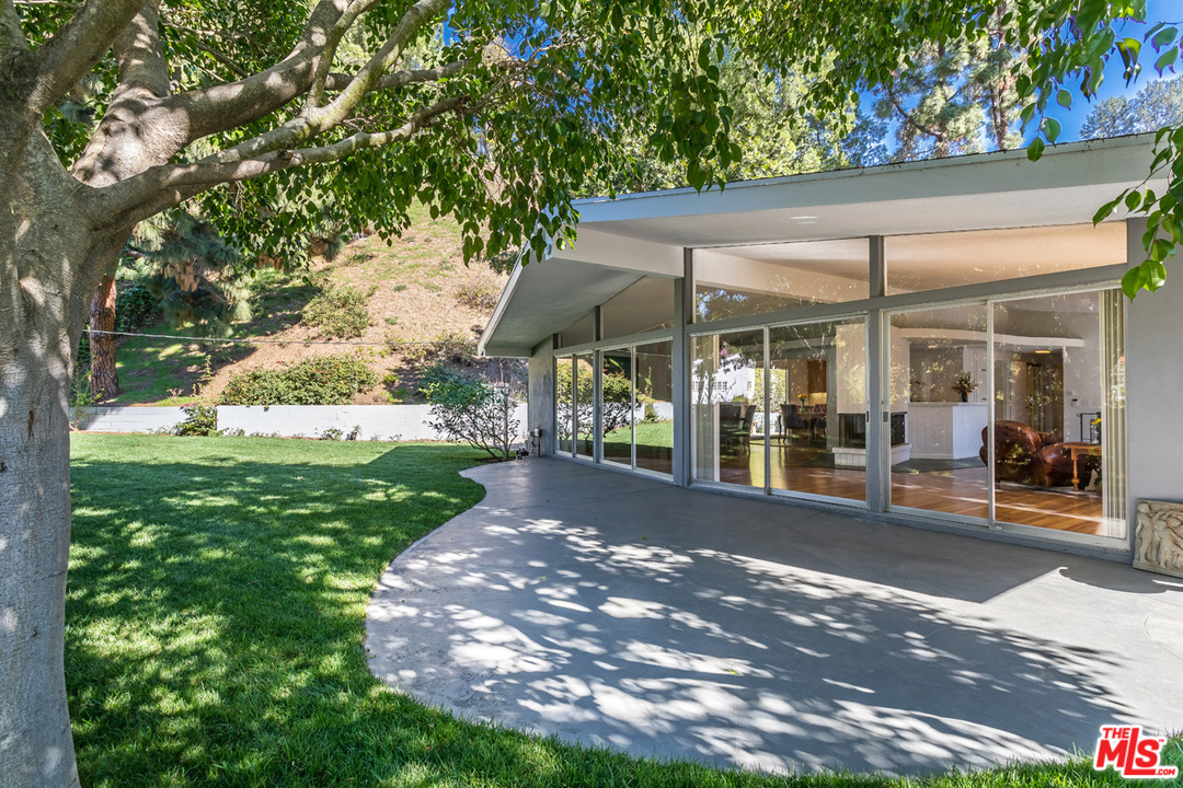 a view of a patio with table and chairs under an umbrella