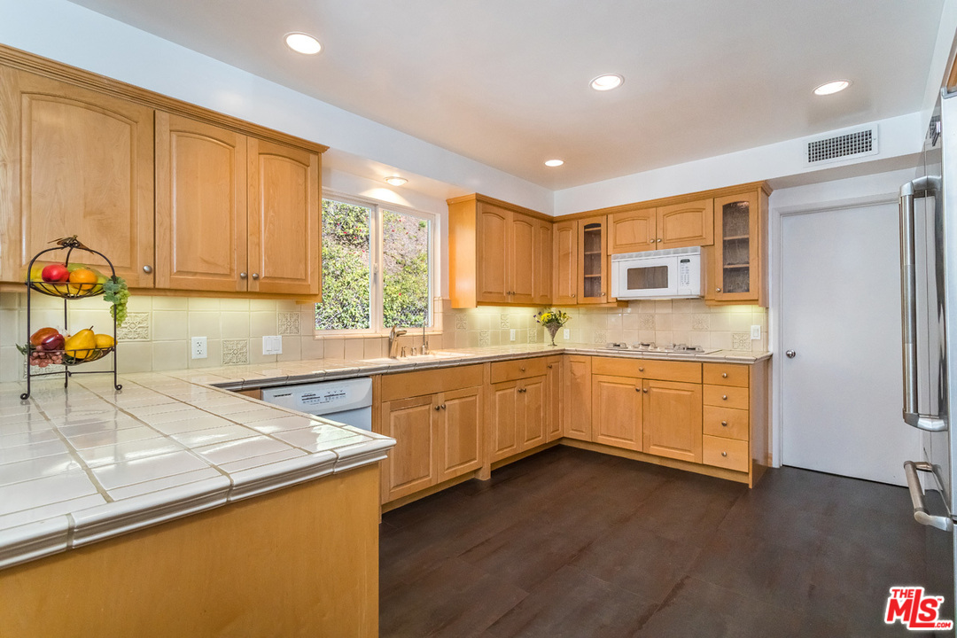 9767 Beth Place Beverly Hills, CA 90210 - Photo 14 of 33 a kitchen with granite countertop a sink cabinets and wooden floor