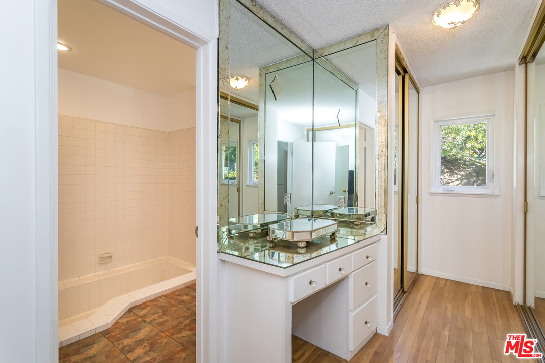 9767 Beth Place Beverly Hills, CA 90210 - Photo 20 of 33 a bathroom with a granite countertop sink and a mirror