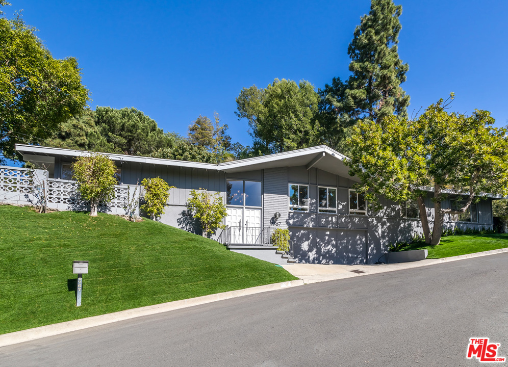 9767 Beth Place Beverly Hills, CA 90210 - Photo 2 of 33 a front view of a house with a yard and garage