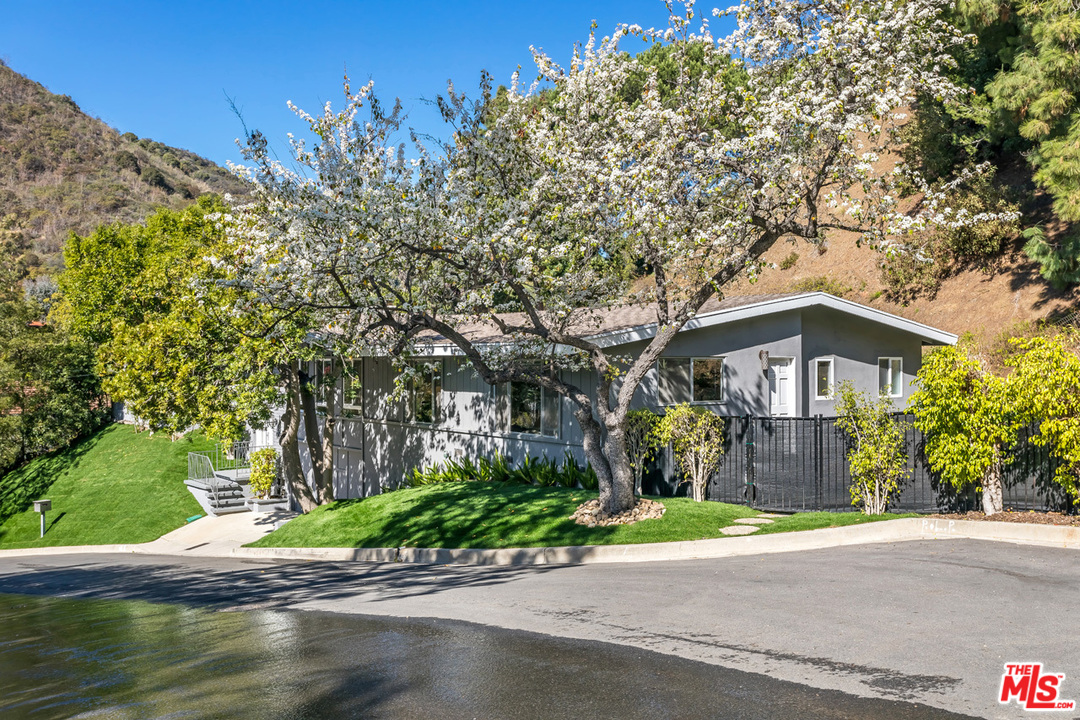 9767 Beth Place Beverly Hills, CA 90210 - Photo 3 of 33 a front view of a house with a yard and garage