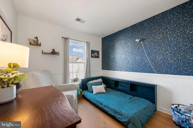 a bedroom with a bed a book shelf and a window