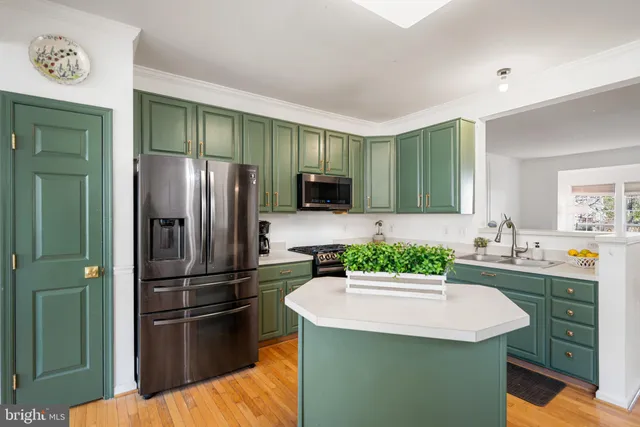 a kitchen with kitchen island a sink stainless steel appliances and cabinets