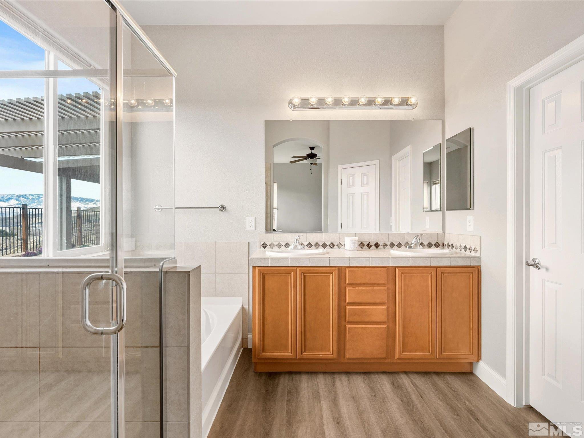 1448 Hagar Road Reno, NV 89506 - Photo 23 of 38 a bathroom with a double vanity sink a mirror and a bathtub