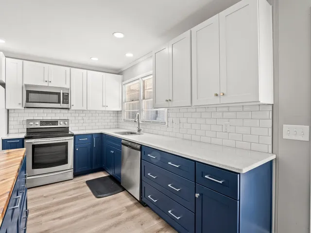 a kitchen with granite countertop cabinets stainless steel appliances and a sink