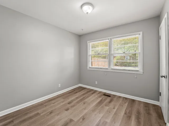 a view of a room with wooden floor and windows