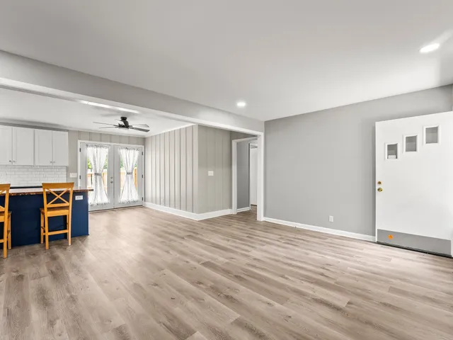 a view of an empty room with window and wooden floor