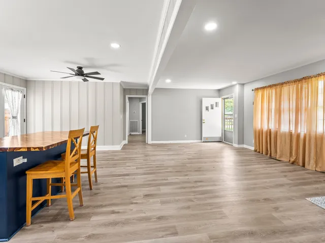 a view of a livingroom with a dinning area wooden floor and furniture