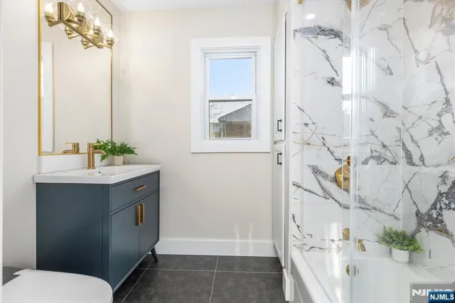 a bathroom with a sink and mirror with toilet