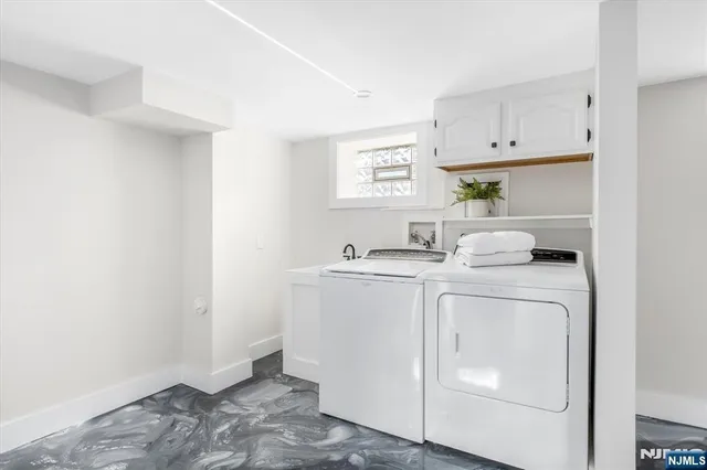 a utility room with cabinets washer and dryer