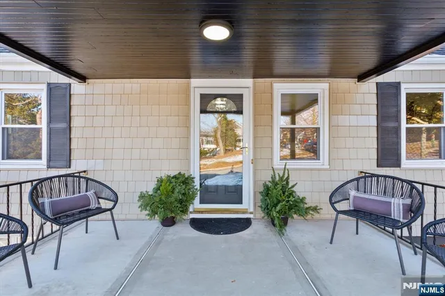 a view of a porch with chairs and potted plants