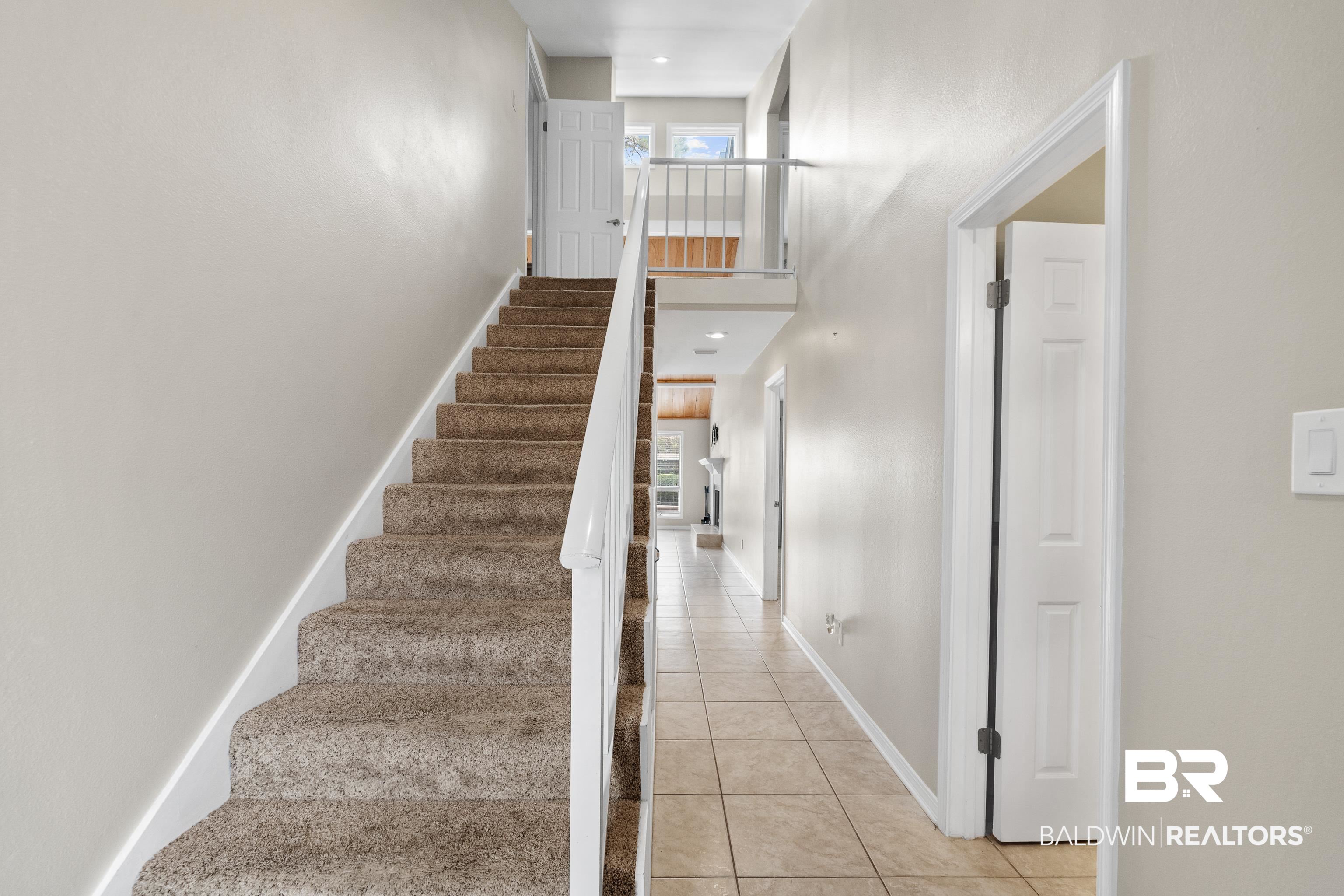 1701 Regency Road, Unit 111 Gulf Shores, AL 36542 - Photo 3 of 29 Stairs with tile patterned flooring