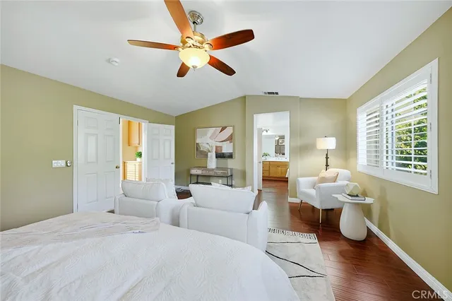 a spacious bedroom with a large bed and a chandelier