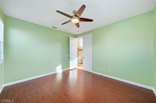 a view of wooden floor and a chandelier fan in a room