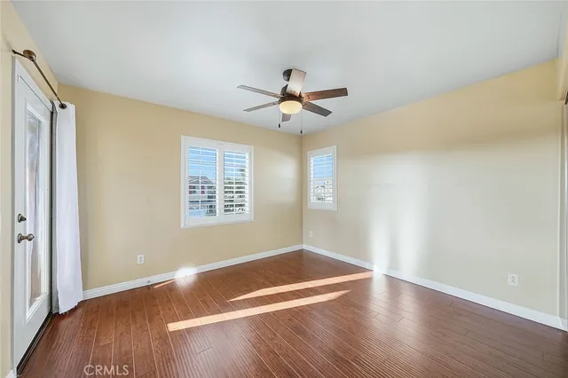 a view of a room with wooden floor and a ceiling fan