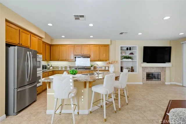 a view of kitchen with stainless steel appliances refrigerator stove microwave and dining table