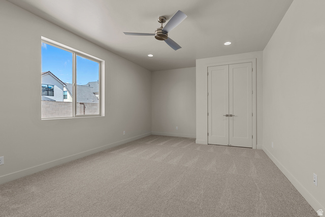 2955 East Rimrunner Drive St. George, UT 84790 - Photo 19 of 35 Spacious room featuring neutral carpeting, a large window, a modern ceiling fan, recessed lighting, and double-door entry
