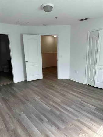 an empty room with wooden floor and closet