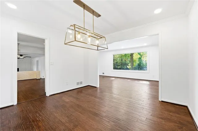 an empty room with wooden floor wooden floor and windows