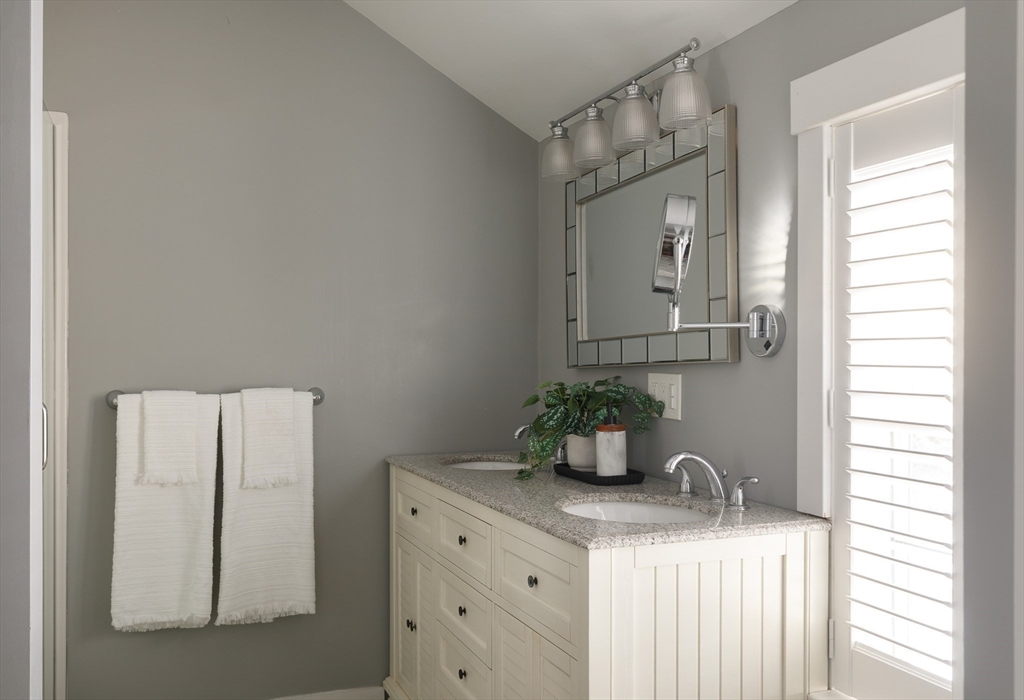 36 High Street Andover, MA 01810 - Photo 12 of 21 a bathroom with a granite countertop sink vanity mirror and vanity
