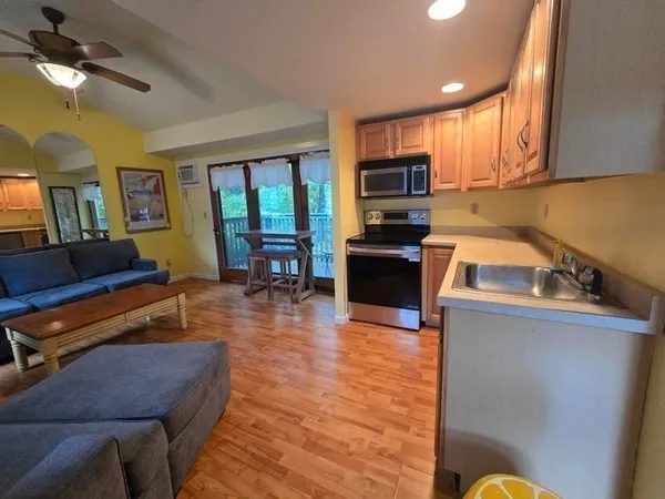 a kitchen with sink a refrigerator and chairs