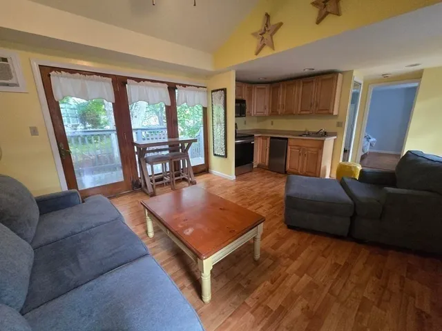 a living room with furniture a large window with kitchen view