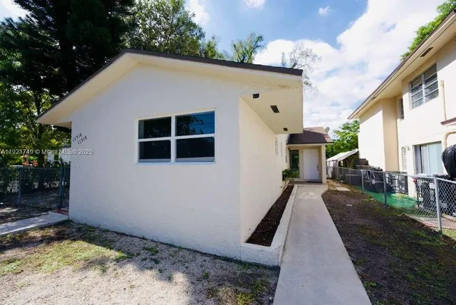 a view of a house with backyard and trees